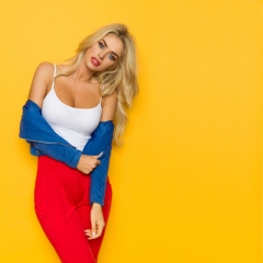 Sexy Blond Woman In Colorful Clothes Is Looking At Camera
